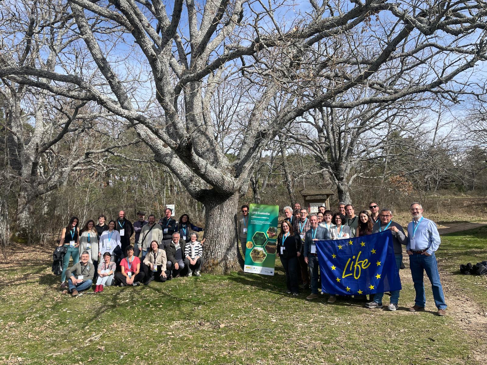 participantes encuentro delante de un árbol